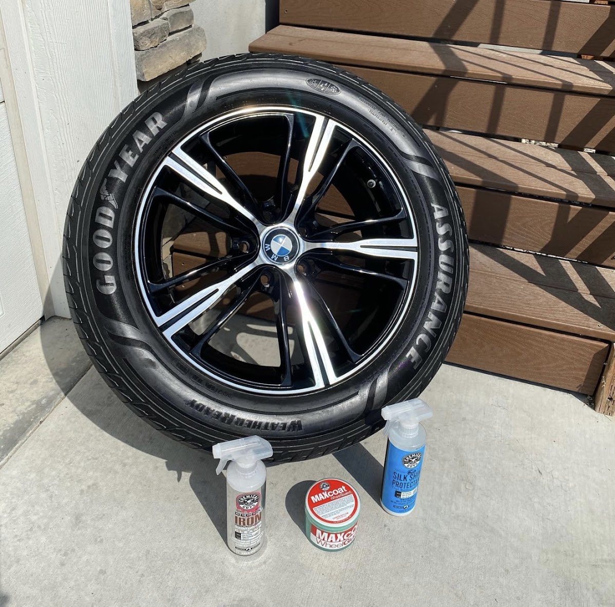 Detailed black and machined BMW wheel with cleaning products